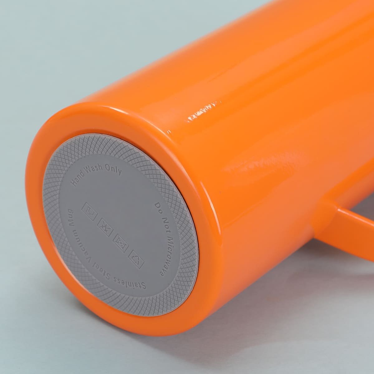 Direct view of the bottom base of the orange thermal flask featuring a grey integrated silicone anti-skid coaster molded with clear hand wash care instructions.