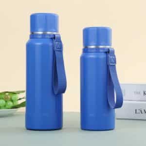 Two royal blue faceted vacuum insulated water Two royal blue faceted vacuum insulated water bottles standing side-by-side in different volumetric size capacities with matching blue carrying loops.Two royal blue faceted vacuum insulated water bottles standing side-by-side in different volumetric size capacities with matching blue carrying loops. faceted vacuum insulated flask with strap