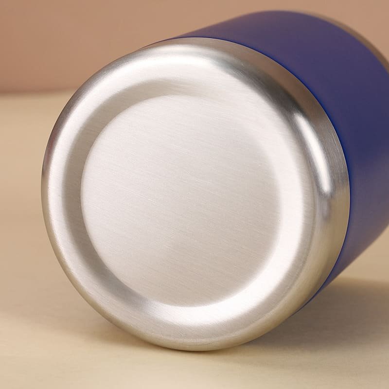 A close up view focused on the thick brushed stainless steel bottom ring of a dark blue lowball insulated camp mug.