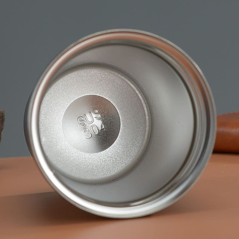 A top-down view inside the empty stainless steel travel cup showing the clear physical SUS 304 steel stamp on the bottom.