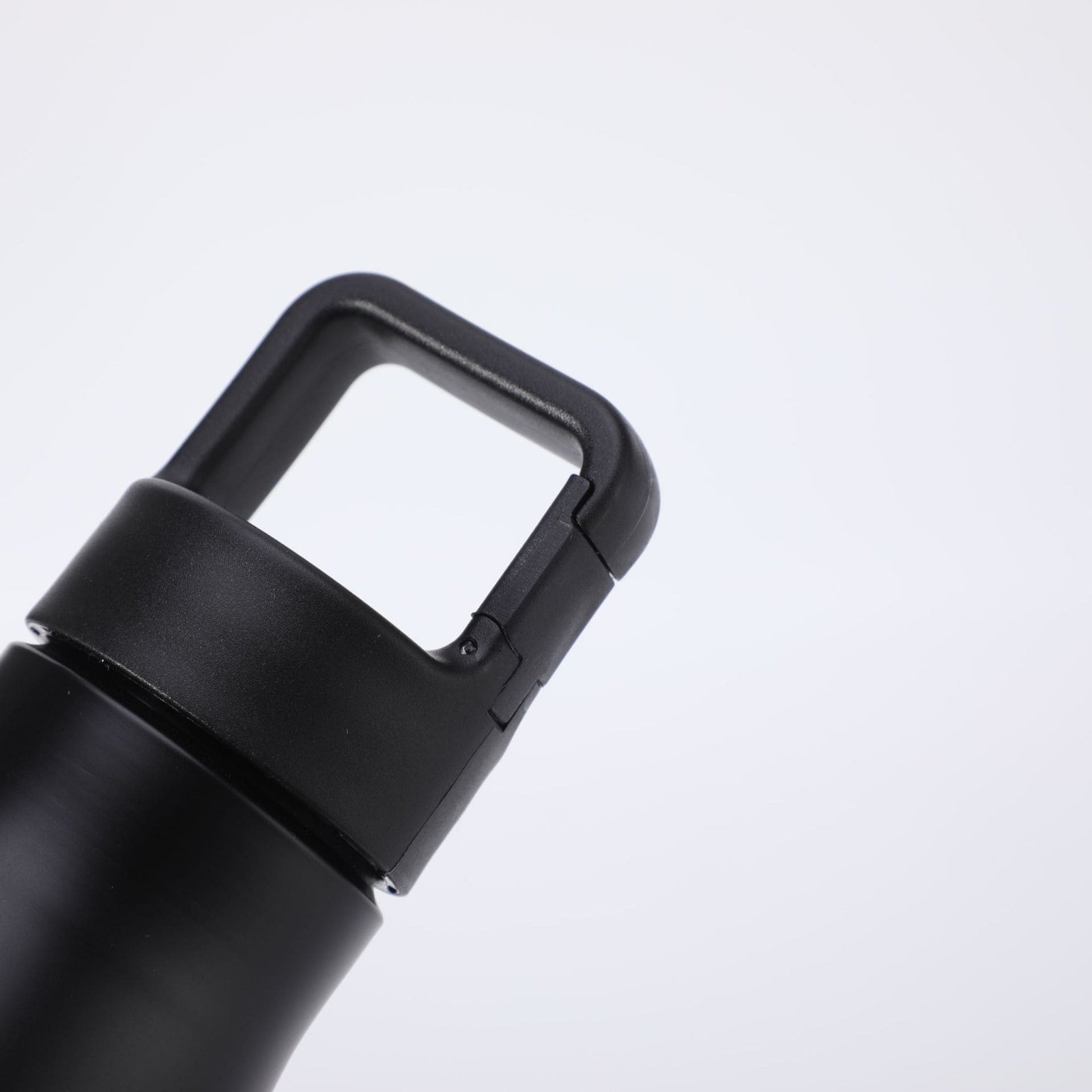 Macro view of single wall stainless steel water bottle cap featuring a heavy duty integrated carabiner clip mechanism