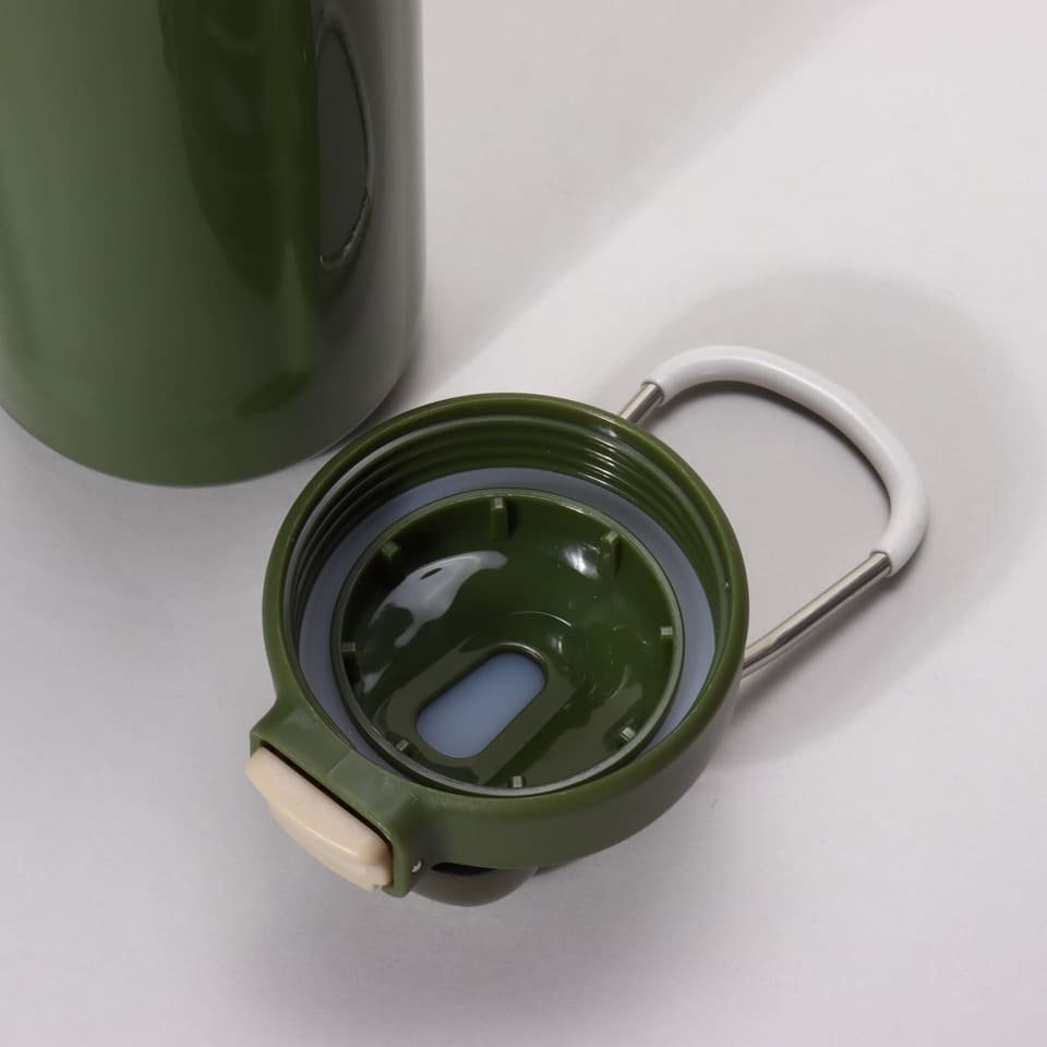 Top down interior view of a detached dark green water bottle cap showing the deep circular rubber sealing ring gasket.